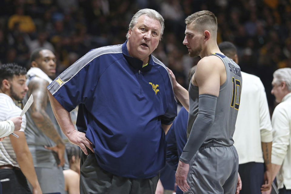 West Virginia coach speaks with guard Erik Stevenson (10) during the first half of an NCAA college basketball game against Kansas State, Saturday, March 4, 2023, in Morgantown, W.Va. (AP Photo/Kathleen Batten)