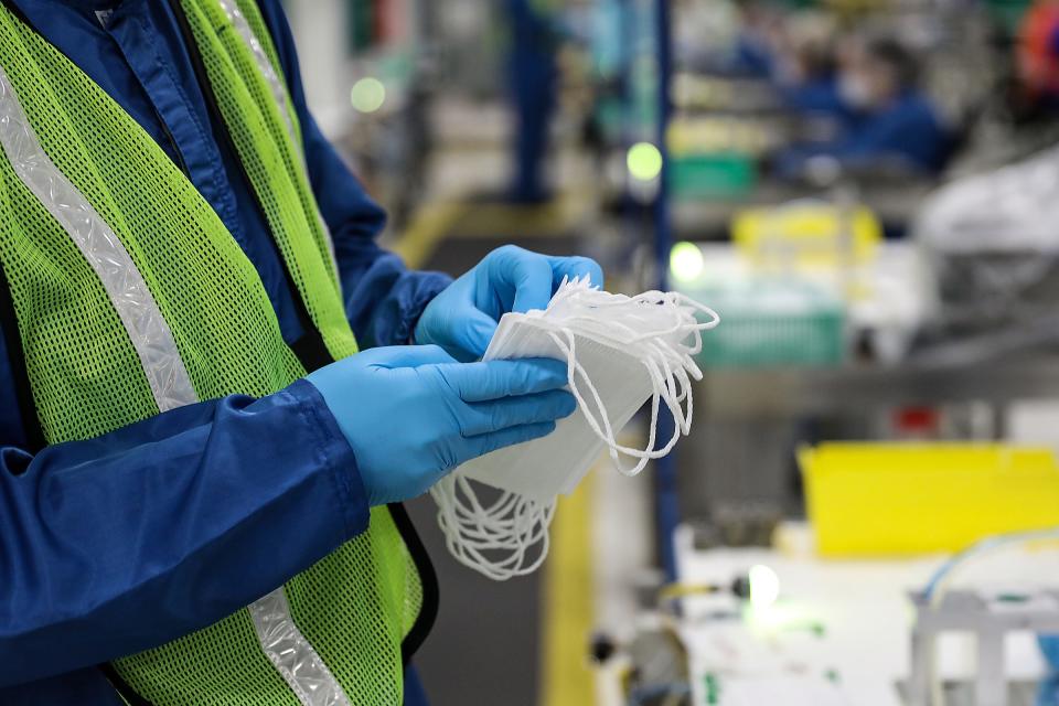 James Varner, oversees the sonic welding process  to attach ear loops to face masks, making sure there are enough materials and counting masks at Edward Johnson's station in the clean room at Warren Transmission Operations plant in Warren, Michigan on April 23, 2020.