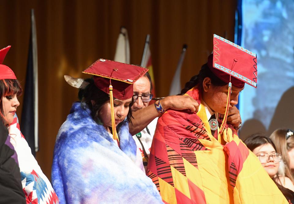 Roosevelt graduate Lakota Little Thunder receives a quilt wrapped around him during a celebration for Native American students graduating from Sioux Falls public schools on Friday, May 27, 2022, at Washington High School.