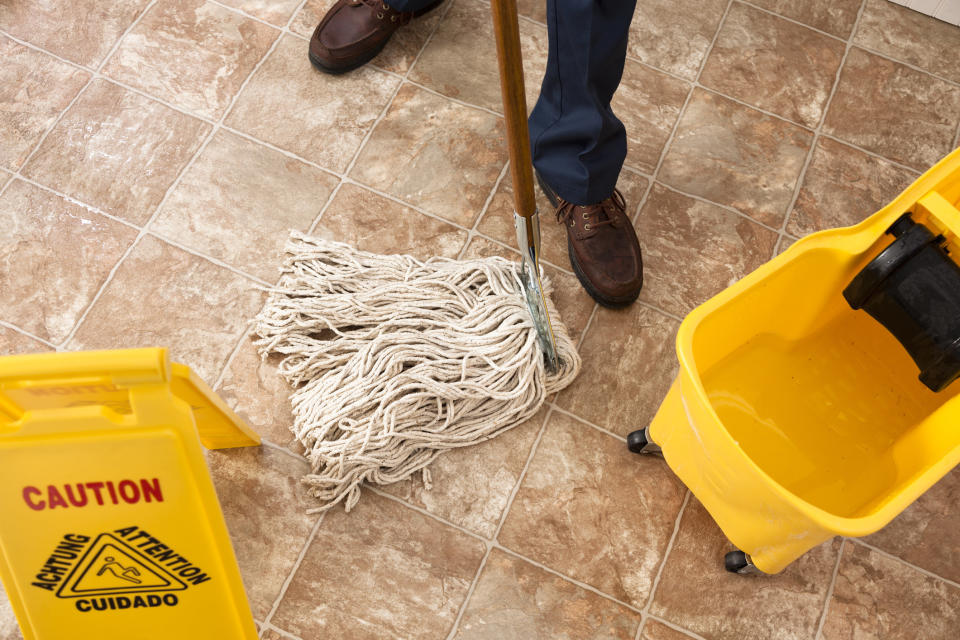 A custodian mopping a floor