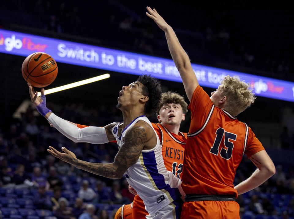 James Madison guard Terrence Edwards, left, takes a shot between Keystone guards Tyler Fox (12) and Jack Anderson (15) during the first half of an NCAA college basketball game in Harrisonburg, Va., Sunday, Dec. 3, 2023. (Daniel Lin/Daily News-Record via AP)