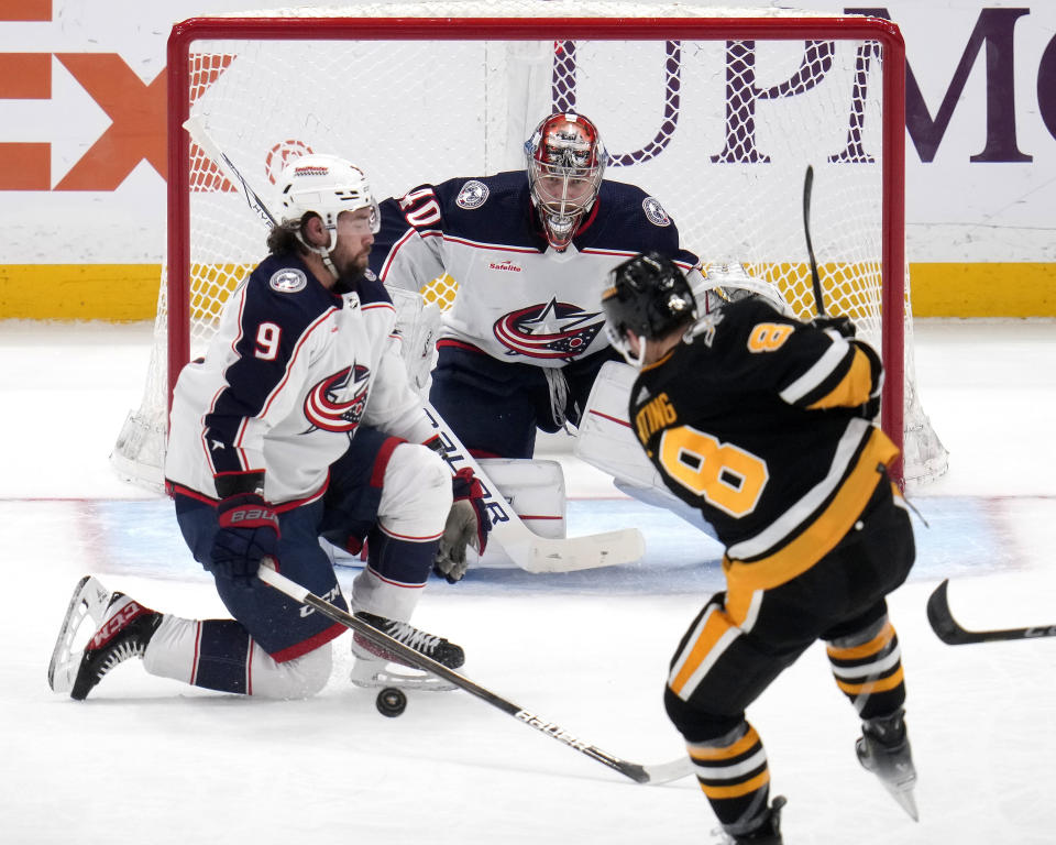 Pittsburgh Penguins' Michael Bunting (8) has a shot blocked by Columbus Blue Jackets' Ivan Provorov (9) in front of goalie Daniil Tarasov (40) during the first period of an NHL hockey game in Pittsburgh, Thursday, March 28, 2024. (AP Photo/Gene J. Puskar)