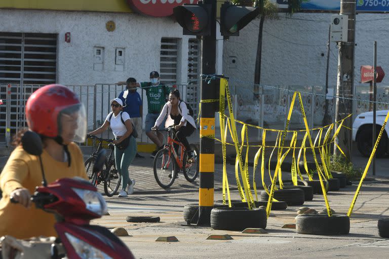 Personas pasan por un bloqueo en el centro de Santa Cruz durante el paro cívico de 24 horas convocado por las autoridades locales en protesta por la detención del gobernador Luis Fernando Camacho, el 30 de diciembre de 2022. (RODRIGO URZAGASTI / AFP)