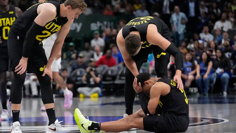 Utah Jazz guard Keyonte George (3) is tackled by teammates Walker Kessler (24) and Lauri Markkanen (23) during the second half of an NBA preseason basketball game against the Dallas Mavericks on Thursday, Oct. 10, 2024, in Dallas. controlled. (AP Photo/LM Otero)