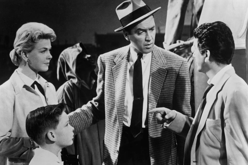 Doris Day, Christopher Olsen, James Stewart, and Daniel Gelin gathered together in a scene from the film 'The Man Who Knew Too Much', 1956. (Photo by Paramount/Getty Images)