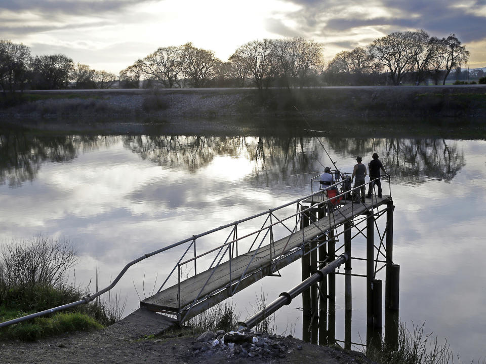 FILE - In this Feb. 23, 2016 file photo, people try to catch fish along the Sacramento River in the San Joaquin-Sacramento River Delta, near Courtland, Calif. Gov. Gavin Newsom officially abandoned the plan of his predecessor, Gov. Jerry Brown, to build giant 35-mile twin tunnels to ship water through the Sacramento-San Joaquin River Delta to Southern California, Thursday, May 2, 2019. Instead, Newsom is opting to build a single tunnel with a different design and a lower price. (AP Photo/Rich Pedroncelli, File)