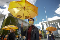 Activists of the Generation-Foundation hold symbolic rescue umbrellas in their hands during a protest in front of the chancellery in Berlin, Germany, Thursday, May 28, 2020. The Generation-Foundation is focusing on climate change and social justice and demand a change of the system for the further generations. The inscriptions on the umbrellas read: 'Generation Rescue Umbrella' - 'Climate Justice Democracy'. (AP Photo/Markus Schreiber)