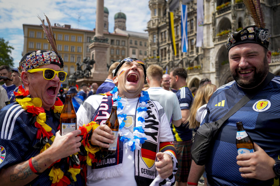 Soccer fans share a laugh in the 'Marienplatz' square, before a Group A match between Germany and Scotland at the Euro 2024 soccer tournament in Munich, Germany, Friday, June 14, 2024. (AP Photo/Markus Schreiber)