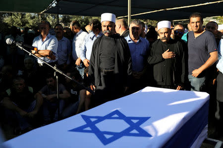 FILE PHOTO: Members of the Druze community stand next to the flag-drapped coffin of Israeli Druze police officer Kamil Shanan during his funeral in the village of Hurfeish, Israel July 14 2017. REUTERS/Ammar Awad/File Photo