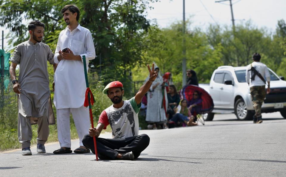 Supporters of Pakistan's former Prime Minister Imran Khan's party gather outside his residence in Islamabad, Pakistan, Monday, Aug. 22, 2022. Pakistani police have filed terrorism charges against Khan, authorities said Monday, escalating political tensions in the country as the ousted premier holds mass rallies seeking to return to office. (AP Photo/Anjum Naveed)