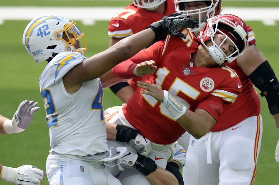 Patrick Mahomes, right, is pressured by Uchenna Nwosu.