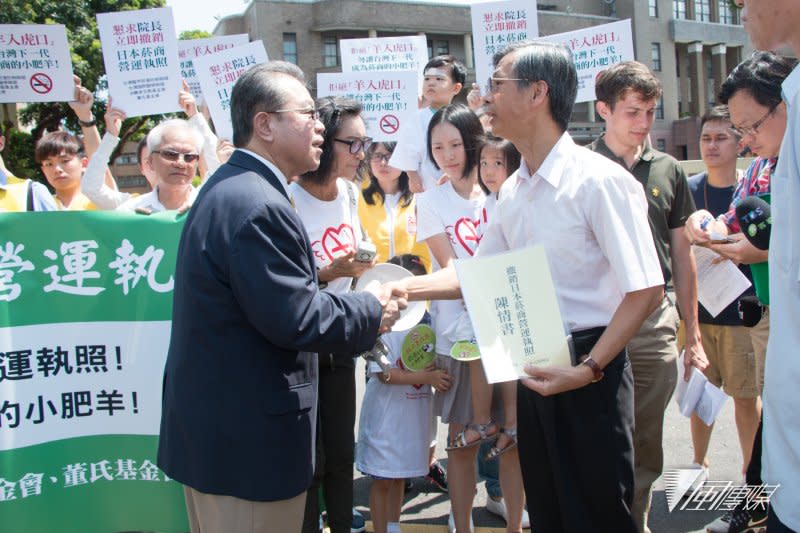 董氏基金會執行長姚思遠與行政院代表握手，「懇求 林全院長救救人民~ 立即撤銷日本菸商營運執照!」記者會發言。（李振均攝）