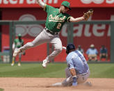 Kansas City Royals' Whit Merrifield (15) beards the tag by Oakland Athletics shortstop Nick Allen (2) to steal second during the third inning of a baseball game Sunday, June 26, 2022, in Kansas City, Mo. (AP Photo/Charlie Riedel)