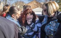 Rose Hunsicker, center, the biological mother of Grace Packer, weeps as she prays with members of Bikers Against Child Abuse outside the church Monday, Jan. 16, 2017, on her way in to a memorial service for Packer, the local teen who who authorities say was killed and dismembered by her adoptive mother and her boyfriend, at the New Life Presbyterian Church in Glenside, Pa. (Ed Hille/The Philadelphia Inquirer via AP)