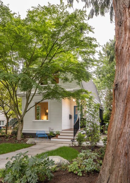 Under a mature tree canopy in Seattle’s Phinney Ridge neighborhood, the 1907 farm cottage boasts original clapboard wood siding and trim, an inviting recessed front porch, and original picture window on the front facade.