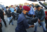 Officials unload the bodies after a helicopter carrying bodies of those killed in Gurja Himal mountain arrives at the Teaching hospital in Kathmandu, Nepal, Sunday, Oct. 14, 2018. Rescuers retrieved the bodies of five South Korean climbers and their four Nepalese guides from Gurja Himal mountain, where they were killed when their base camp was swept by a strong storm. (AP Photo/Niranjan Shrestha)