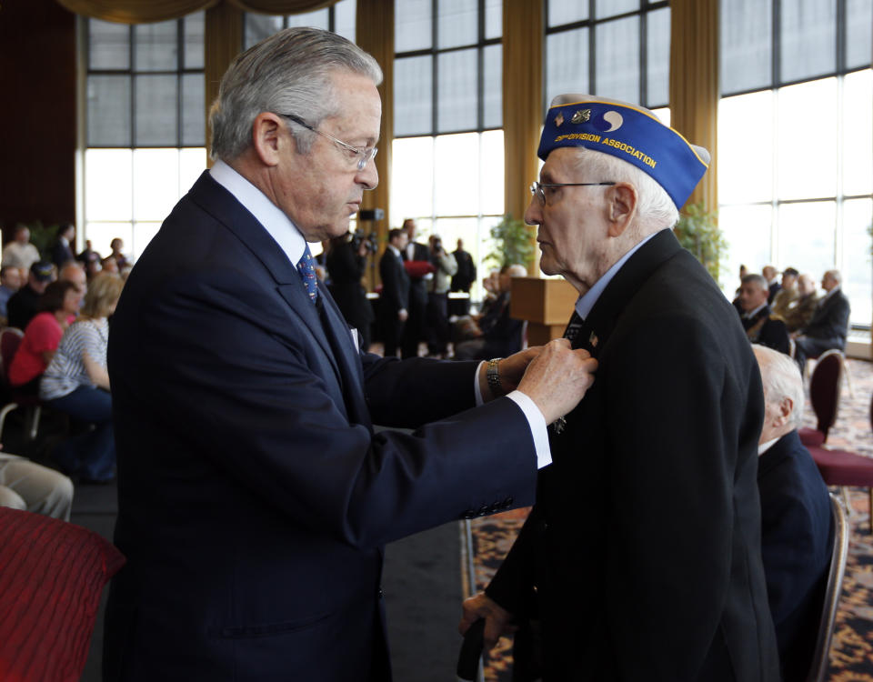 Guy Wildenstein, president of the American Society of the French Legion of Honor, left, presents an the legion's insignia to World War II veteran John Peregrim of Devon, Conn., during a ceremony at the U.S. Military Academy on Friday, May 9, 2014, in West Point, N.Y. Thirty-four veterans were honored 70 years after of the D-Day landings. (AP Photo/Mike Groll)