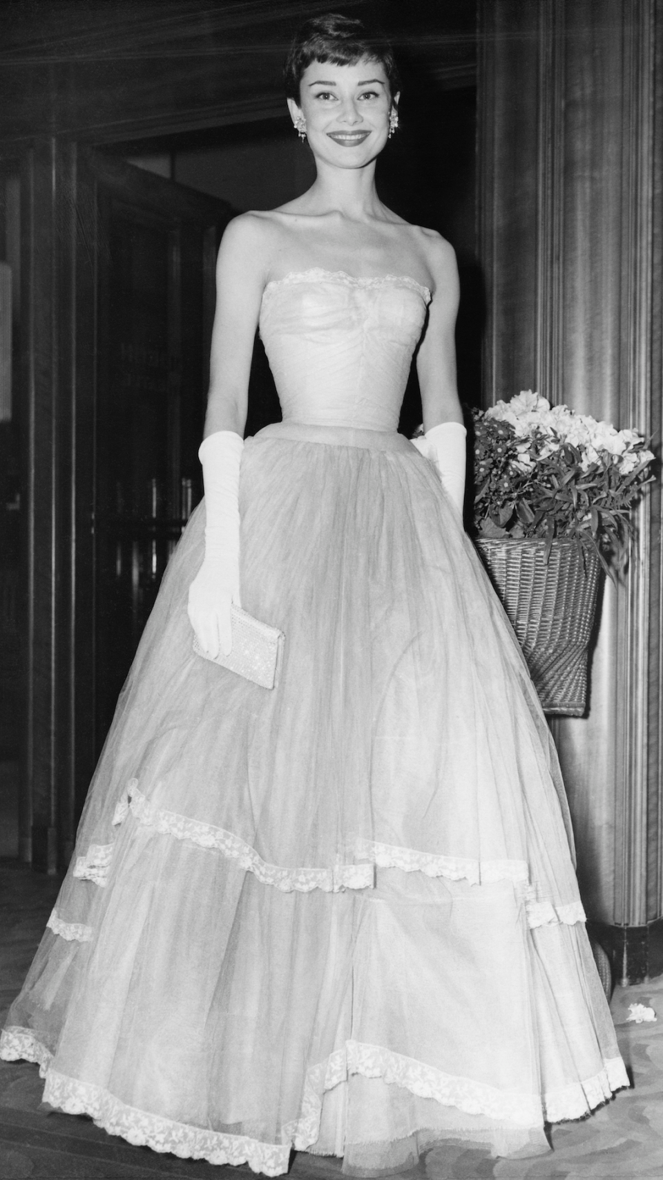 <p> Audrey Hepburn is the definition of old school Hollywood glamour. At the BAFTAs in 1955, the iconic actress wore a sweeping strapless gown - featuring a voluminous skirt - and finished off the look with long white gloves and a clutch bag. </p>