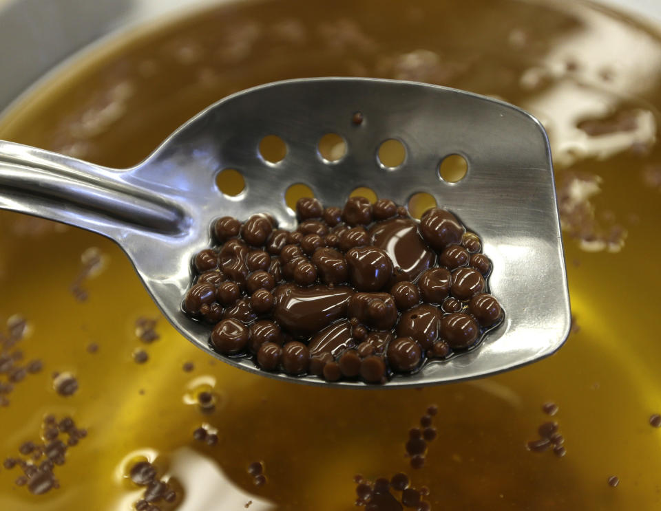 In this image taken on Friday, Sept. 14, 2012, chocolate pearls that will be used as a dessert garnish are removed from cold canola oil at the Culinary Institute of America in Hyde Park, N.Y. This esteemed cooking school north of New York City is dramatically pumping up science instruction, saying that tomorrow's chefs will need more technical know-how in the age of molecular gastronomy and sous-vide. (AP Photo/Mike Groll)