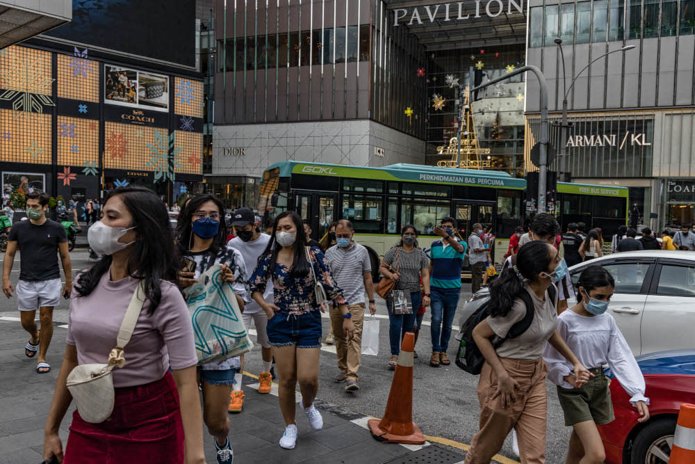 People are seen wearing protective masks as they walk along the Bukit Bintang shopping area in Kuala Lumpur, December 30, 2021. — Picture by Firdaus Latif