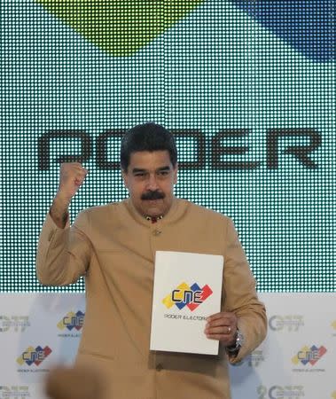 Venezuela's President Nicolas Maduro holds a document during his meeting with National Electoral Council (CNE) President Tibisay Lucena (Not pictured) in Caracas, Venezuela July 31, 2017. Miraflores Palace/Handout via REUTERS