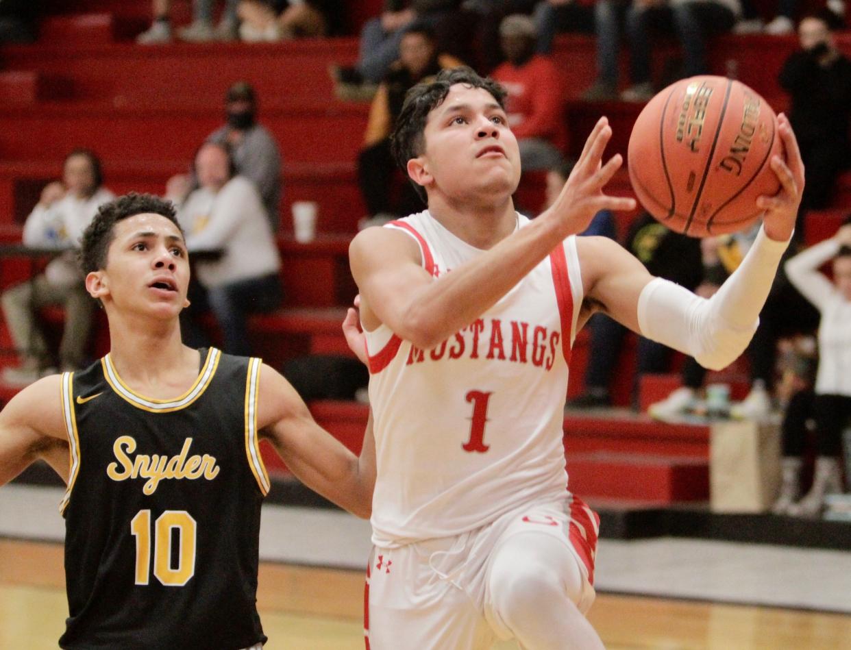 Sweetwater senior Armando Torres attempts a layup while guarded by Snyder's Jared Smith on Tuesday, Jan. 18, 2022.