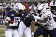 Northern Arizona running back Kevin Daniels (22) stiff arms Arizona defensive lineman Mo Diallo during the first half of an NCAA college football game, Saturday, Sept. 18, 2021, in Tucson, Ariz. (AP Photo/Rick Scuteri)