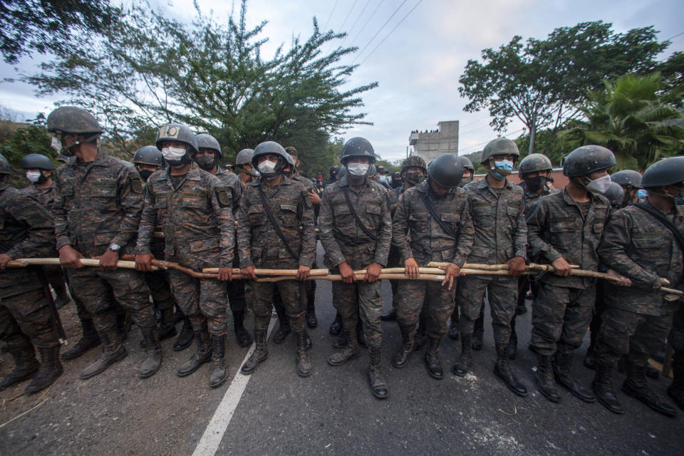 Guatemalan soldiers block part of a Honduran migrant caravan in their bid to reach the U.S. border, in Vado Hondo, Guatemala, Sunday, Jan. 17, 2021. (AP Photo/Sandra Sebastian)