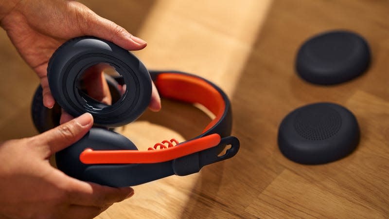 A user demonstrating how the Logitech Zone Learn's earcups can be easily removed and swapped.