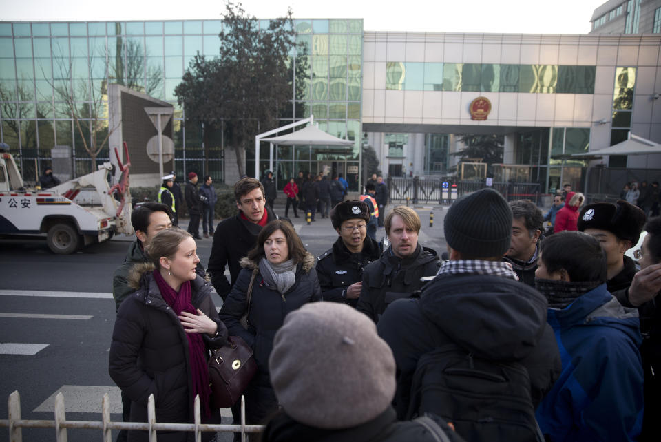 Chinese policemen try to block foreign diplomats talking to journalists as they prepare to attend a trial of Xu Zhiyong outside the Beijing's No. 1 Intermediate People's Court, China Wednesday, Jan. 22, 2014. The trial of the prominent activist who has led a grassroots campaign demanding a fairer society and official accountability to better fight corruption started in Beijing, while police blocked journalists and supporters from getting near. Xu stood trial Wednesday, accused of disrupting public order. (AP Photo/Andy Wong)