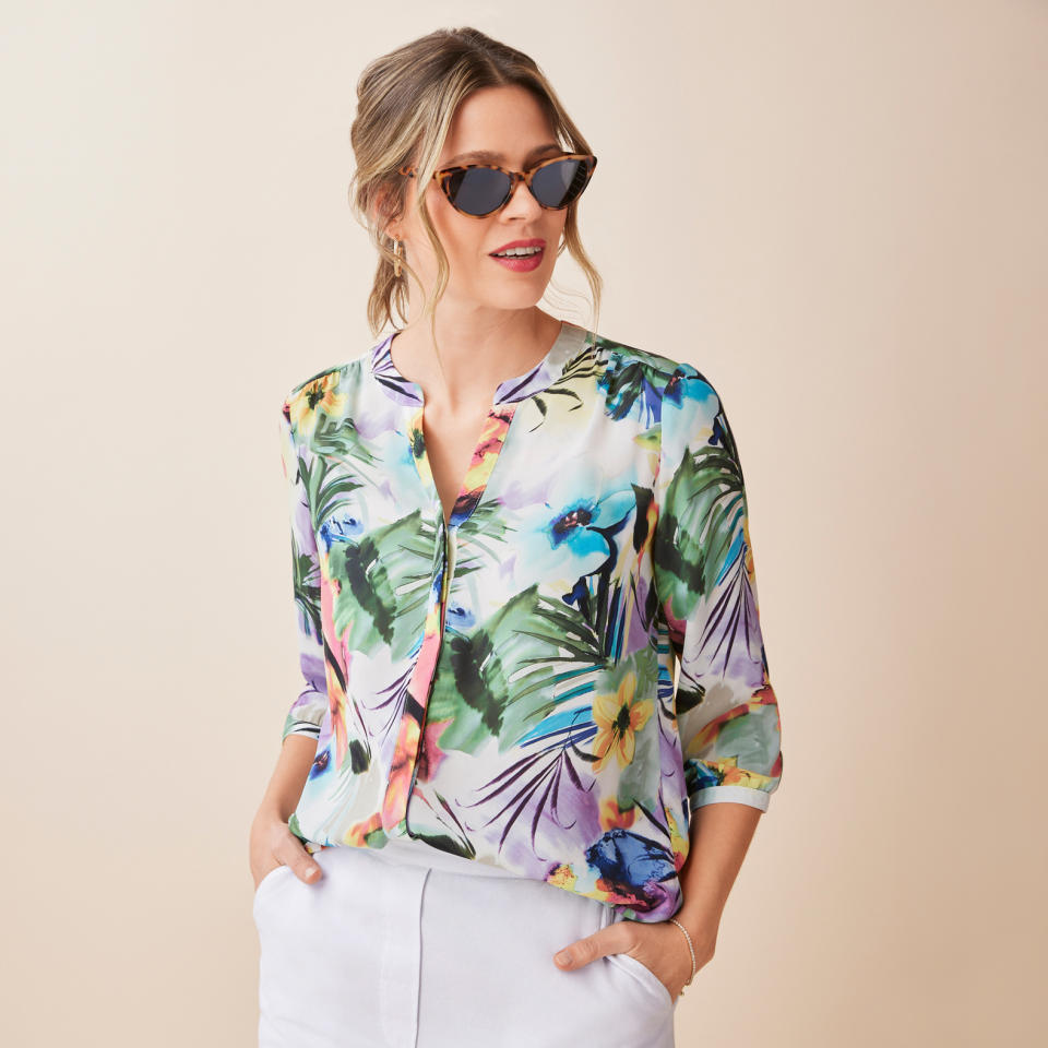 model wearing sunglasses, white trousers, and floral Watercolour Print Top (photo via Northern Reflections)