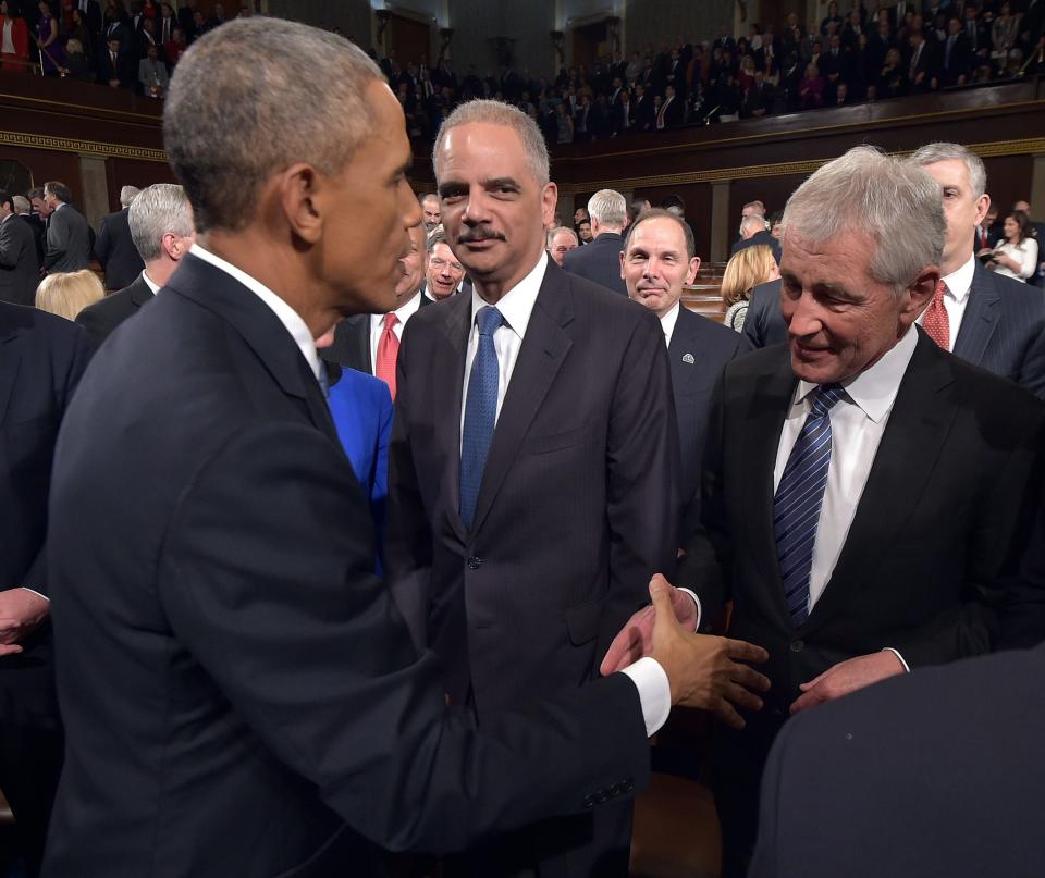 U.S. President Obama greets outgoing Defense Secretary Hagel and Attorney General Holder after State of the Union address to a joint session of Congress on Capitol Hill in Washington