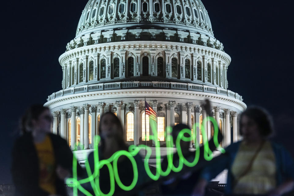 Activists mark the first anniversary of the Supreme Court's decision in Dobbs v. Jackson Women's Health Organization, the case widely considered to have overturned Roe v. Wade, by displaying neon signage in support of abortion access in front of the US Capitol on Friday, June 23, 2023, Washington. (AP Photo/Nathan Howard)