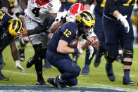 Michigan quarterback Cade McNamara is sacked by Georgia defensive lineman Travon Walker during the second half of the Orange Bowl NCAA College Football Playoff semifinal game, Friday, Dec. 31, 2021, in Miami Gardens, Fla. (AP Photo/Lynne Sladky)