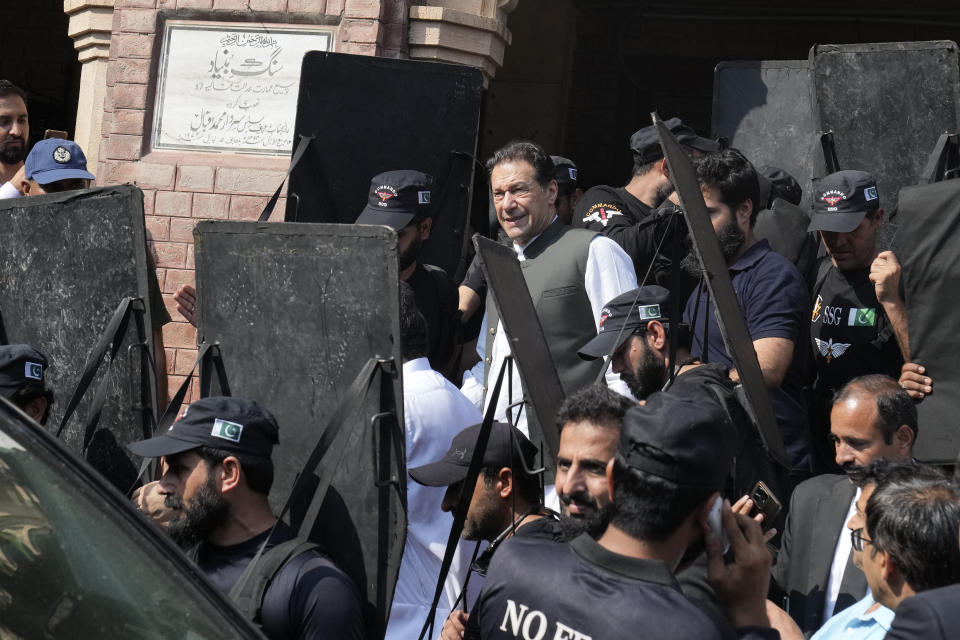 Pakistan's former Prime Minister Imran Khan, center, leaves after appearing in a court in Lahore, Pakistan, Monday, June 26, 2023. Khan faces more than 100 legal cases, including on graft charges during his 2018-2022 term as premier, and has also been charged with terrorism for inciting people to violence. In court, he has won protection from arrest in multiple cases, pending trial. (AP Photo/K.M. Chaudary)