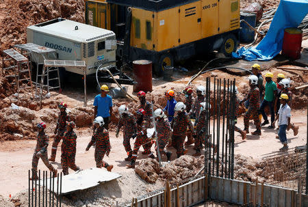 Rescue workers carry the body of a landslide victim at a construction site in Tanjung Bungah, a suburb of George Town, Penang, Malaysia October 22, 2017. REUTERS/Lai Seng Sin