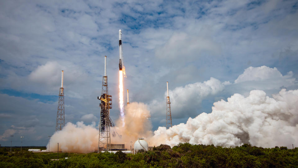     Eine schwarz-weiße Rakete startet in einen wolkenverhangenen blauen Himmel. 