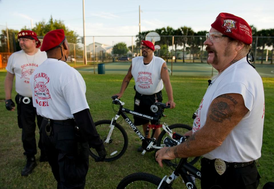 Steve "Crusader" Horton (right), a member of the Treasure Coast Guardian Angels, speaks with fellow members Bryan "Scorpion" Russe (left), Ned "Preacher" Childress and Mark "Lifeguard" Peterson while patrolling the area near the basketball courts on March 29, 2012, at Sportsman's Park in Port St. Lucie. "We will saturate the area until the dark cloud dissipates," said Horton. "We will maintain after that." The area was the site of a shooting in March that left one man dead.