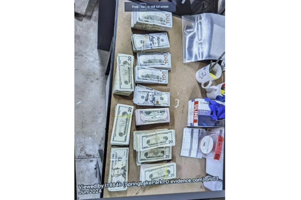 This photo supplied by the U.S. Attorney's Office for Minnesota shows cash from a bag that was left at the home of a juror in a massive fraud case, June 2, 2024, outside Minneapolis, Minn. Authorities have confiscated cellphones and taken all seven defendants into custody as investigators try to determine who attempted to bribe the juror to acquit them on charges of stealing more than $40 million from a program meant to feed children during the pandemic. (U.S. Attorney's Office for Minnesota via AP)