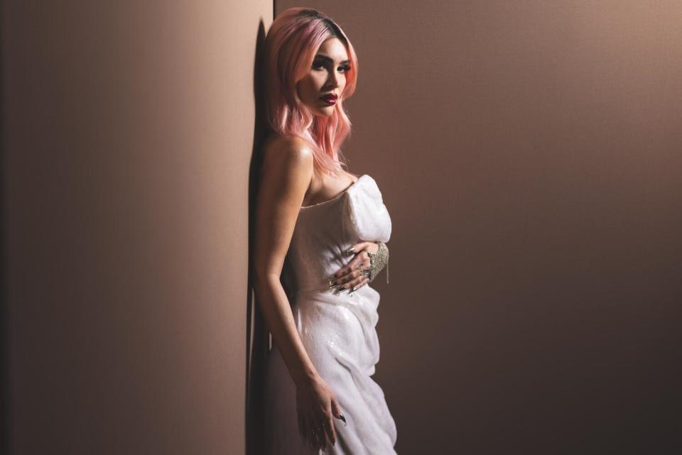 Megan Fox, with pink hair in a white strapless dress.