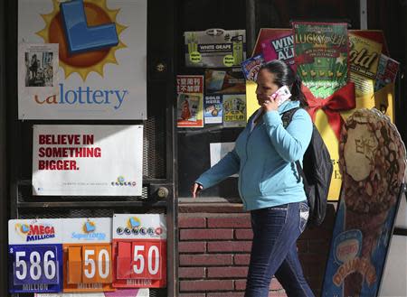 A woman walks past a Mega Millions lottery sign with the estimated jackpot of $586 million posted in Los Angeles, California December 16, 2013. REUTERS/Jonathan Alcorn