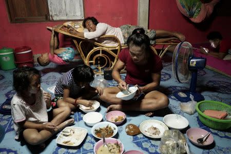 Muay Thai boxer Nong Rose Baan Charoensuk, 21, who is transgender, eats dinner with her family members at her home in Phimai district in Nakhon Ratchasima province, Thailand, July 18, 2017. REUTERS/Athit Perawongmetha