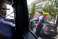 Patrolman George Newell, left, checks on fellow police officers while patrolling through the Auburn Gresham neighborhood in Chicago, Tuesday, Aug. 25, 2020. In a chaotic year destined for the history books, Auburn Gresham has written its own grim chapter. This Black community on the city's South Side has endured a deadly virus, gun violence and economic misery, a constant state of turmoil that mirrors the tumult afflicting much of urban America. (AP Photo/David Goldman)