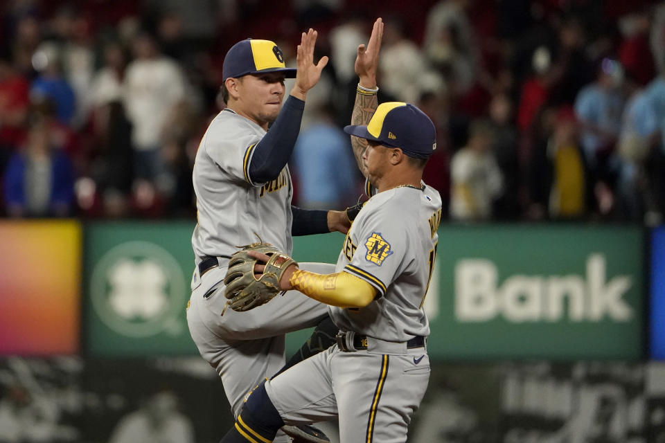 Milwaukee Brewers' Luis Urias, left, and Kolten Wong celebrate a 4-3 victory over the St. Louis Cardinals following a baseball game Thursday, May 26, 2022, in St. Louis. (AP Photo/Jeff Roberson)