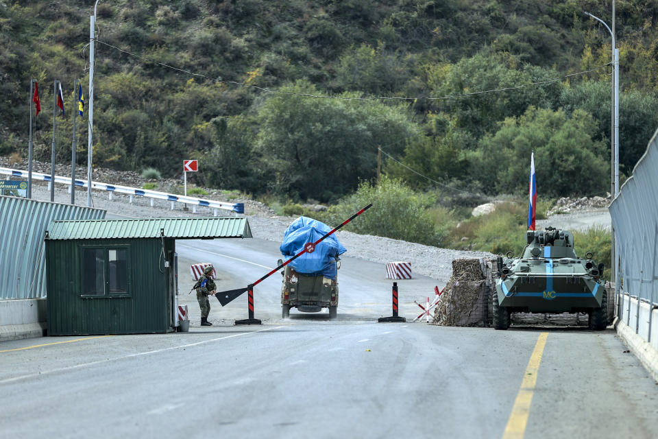 Sergey Astsetryan, an ethnic Armenian resident of Nagorno-Karabakh, drives his Soviet-made vehicle past Russian peacekeepers after been checked by Azerbaijani border guard servicemen at the Lachin checkpoint on the way from Nagorno-Karabakh to Armenia, in Azerbaijan, Sunday, Oct. 1, 2023. Astsetrayn was one of the last residents of Nagorno-Karabakh to drive out of the region in his own vehicle as part of a grueling weeklong exodus of over 100,000 people — more than 80% of the residents — after Azerbaijan reclaimed the area in a lightning military operation. (AP Photo/Aziz Karimov)