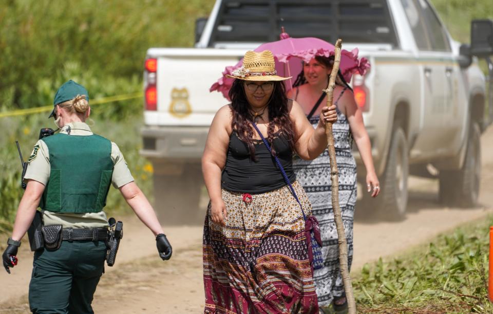 U.S. Forest Service law enforcement rangers walk through a parking area at the Rainbow Family gathering on June 26.