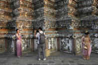 A Chinese tourist in traditional Thai dress poses for a photograp at Wat Arun or the "Temple of Dawn" in Bangkok, Thailand on Jan. 12, 2023. A hoped-for boom in Chinese tourism in Asia over next week’s Lunar New Year holidays looks set to be more of a blip as most travelers opt to stay inside China if they go anywhere. (AP Photo/Sakchai Lalit)