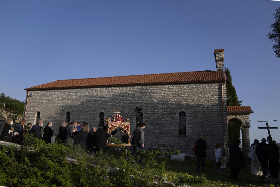 Faithful follow the procession of Jesus' funeral bier, called the "Epitaph" in Greek, at Agios Georgios church in Myrodafni village, Epirus region, northwestern Greece, on Good Friday, April 22, 2022. For the first time in three years, Greeks were able to celebrate Easter without the restrictions made necessary by the coronavirus pandemic. (AP Photo/Thanassis Stavrakis)