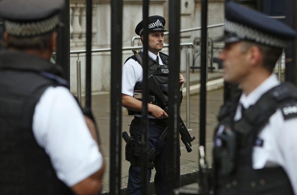 Armed police officers are seen on duty in Downing Street, central London September 1, 2014. British Prime Minister David Cameron said on Monday he would bring in new laws to give police the power to seize the passports of suspected Iraq and Syria-bound Islamist fighters. REUTERS/Luke MacGregor (BRITAIN - Tags: POLITICS CONFLICT CRIME LAW)