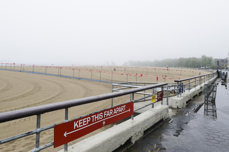 New York City Parks officials work at an empty Orchard Beach Saturday, May 23, 2020, in the Bronx borough of New York. Gov. Andrew Cuomo has given New Yorkers an unexpected reprieve from cabin fever by easing the state’s ban on gatherings due to coronavirus concerns, in time for the Memorial Day weekend. New York City beaches are open this weekend. But no swimming is allowed, and masks must be worn. (AP Photo/Frank Franklin II)